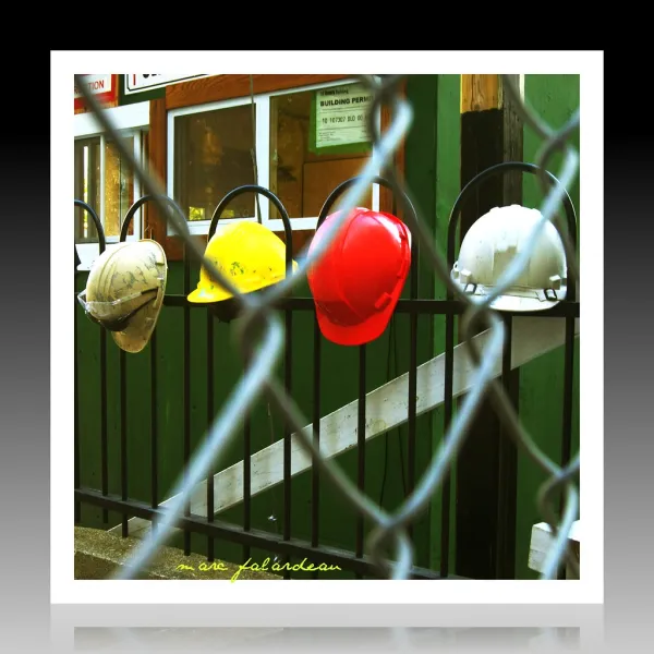 work hats hanging on a a fence